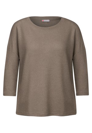 Haut long à manches brun, texturé, avec un col rond et une coupe décontractée. Manches larges et finition standard en bas. Étiquette de marque visible.