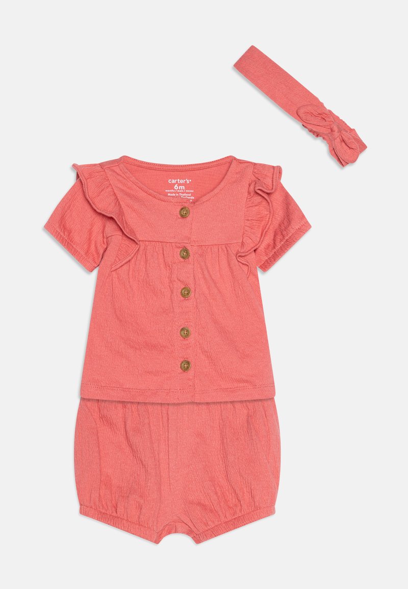 Korallfarbenes Babyoutfit mit einem kurzärmligen Oberteil mit Rüschenschultern und Holzknöpfen, kombiniert mit passenden Shorts mit elastischem Bund und einem Haarband.