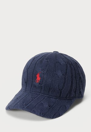 Cappello in maglia navy con motivo a trecce, visiera curva e logo ricamato rosso. Tessuto morbido con una vestibilità strutturata.