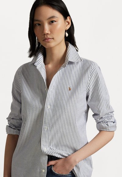 Gestreiftes Button-up-Hemd in Hellblau und Weiß mit umgeschlagenen Ärmeln und einem gestickten Logo auf der Brust. Glattes Baumwollgewebe.