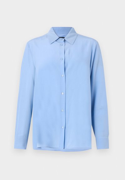 Camicia azzurro chiaro con colletto, maniche lunghe e una texture di tessuto liscia; presenta bottoni frontali e una vestibilità leggermente rilassata.