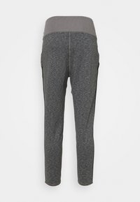 Pantalones de chándal ajustados en gris oscuro con una cintura elástica más oscura y ancha, vistos desde la parte posterior contra un fondo simple.