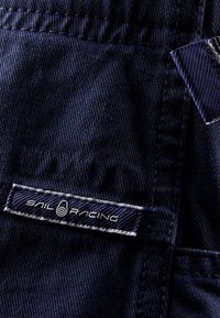 Marine stof patch met het "SAIL RACING" logo in het wit. De textuur is glad met fijne stiksels en een lichte glans.
