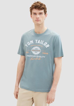 Hellblaues Baumwoll-T-Shirt mit weißen und orangenen Drucktexten, Rundhalsausschnitt, kurzen Ärmeln und geradem Saum. Lässiges Design.