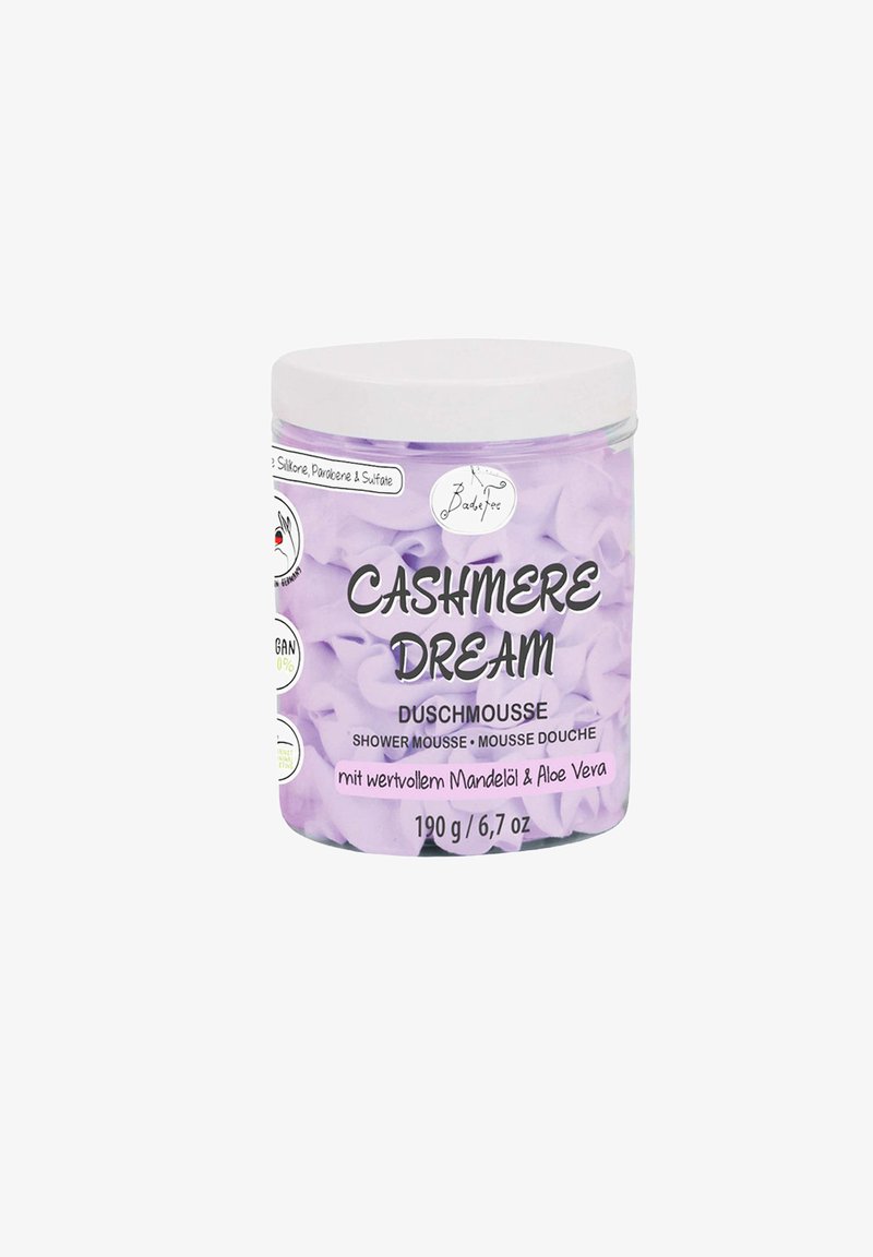 Cashmere Dream shower mousse in a clear container with a white lid. Purple packaging with text; 190 g/6.7 oz. Contains almond oil and aloe vera.