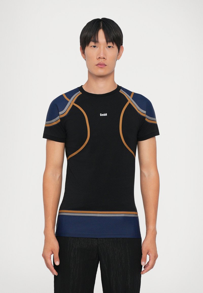 Zwart sportshirt met contrasterende marineblauwe en oranje accenten, aansluitende pasvorm, ronde halslijn en logo in het midden. Soepele textuur.