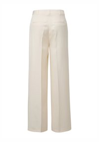 Spodnie w szerokim kroju w jasnobeżowym materiale. Posiadają gładką strukturę, boczne i tylne kieszenie oraz dopasowaną talię.