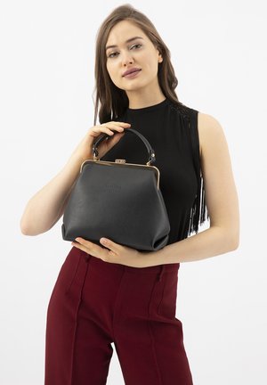 Borsa a tracolla in pelle nera con una forma strutturata, chiusura in metallo dorato e manico corto. Texture morbida con finitura a rondini.