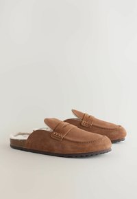Pruun nahkseentëd, valge vale karvaga voodriga, kaarega varvaste disainiga ja aktsentõmblusega. Tekstuuriga kummist tallad haardeks.