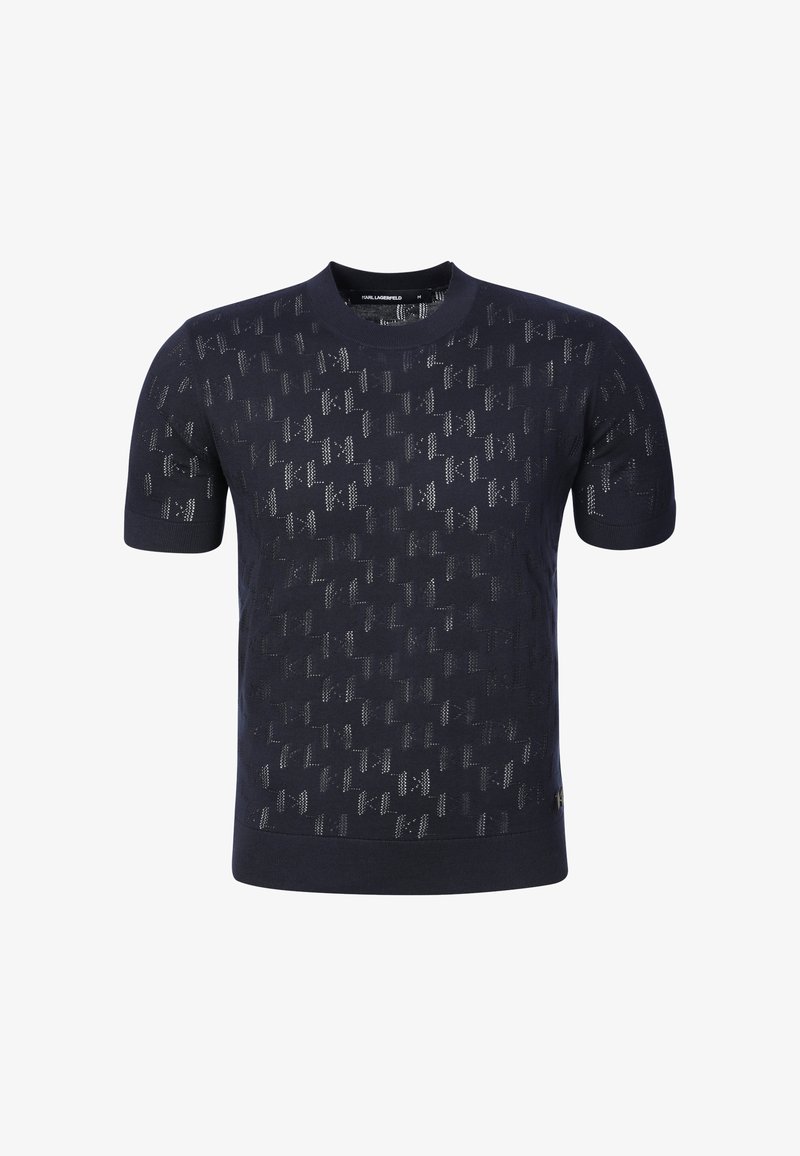 Chemise en maille bleu marine à manches courtes avec un motif perforé subtil et un col rond, étiquette de taille moyenne visible à l'intérieur du col.