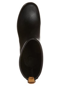 Bottine noire en caoutchouc avec une finition lisse, un bout rond et une boucle beige pour un enfilage facile. Doublure intérieure noire texturée.