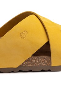 Sandalia de ante amarillo con correas entrecruzadas y una plantilla de corcho. Suela de goma texturizada para mayor agarre, con un pequeño detalle de logo en relieve.