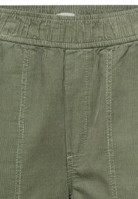 Pantalon en velours côtelé vert avec taille élastique, présentant un côtelage vertical, des coutures latérales et des détails cousus. Aucune poche visible.