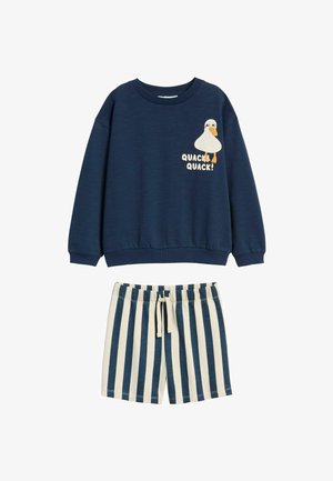 Donkerblauwe sweatshirt met een eendenafbeelding en de tekst "QUACK QUACK!", gecombineerd met crèmekleurige en donkerblauwe gestreepte shorts met een elastische tailleband.