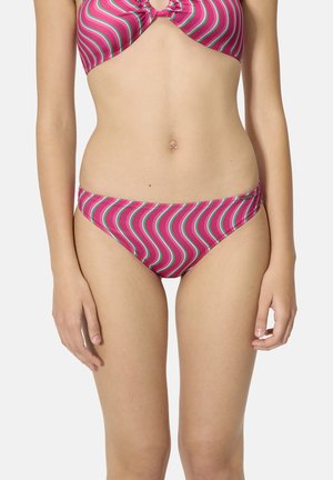 Mujer con bikini de rayas onduladas en rosa y verde, parte inferior y superior a juego, de pie contra un fondo liso y claro.