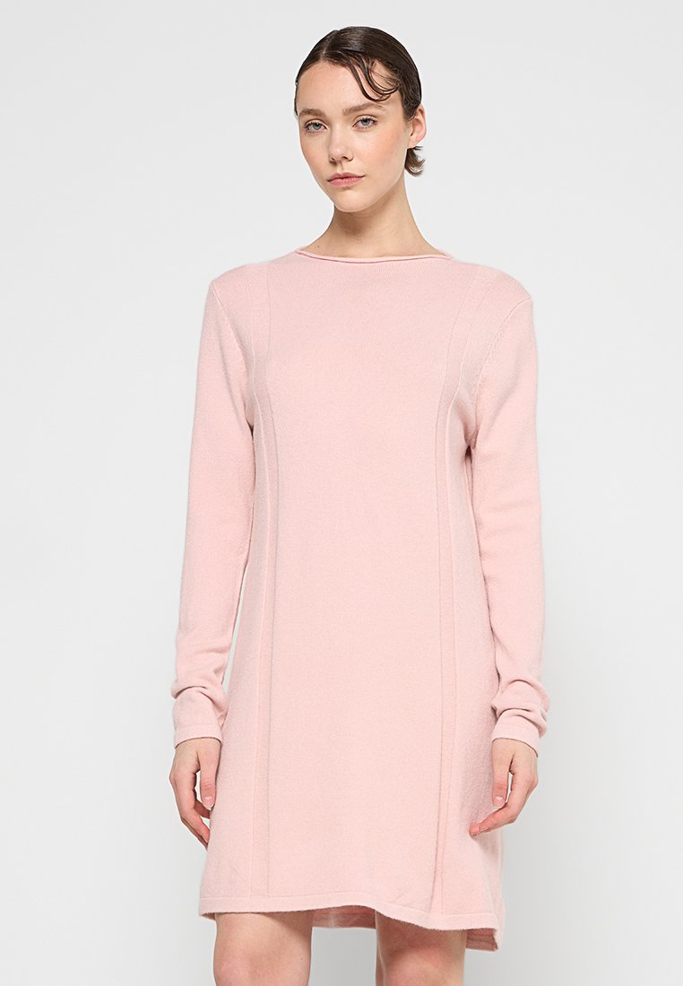 Helles rosa Langarmkleid mit rundem Ausschnitt, das vertikale Nahtdetails und eine lockere Passform aufweist, hergestellt aus einem weichen Strickmaterial.