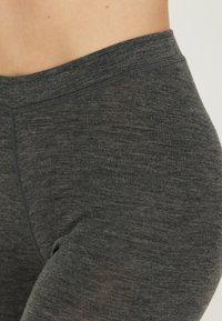 Leggings de color gris oscuro con una textura suave, tela blanda y una cinturilla elástica, diseñadas para ofrecer comodidad y flexibilidad.