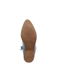 Zapato de ante azul claro con un tacón bajo y suela de goma. La suela tiene una textura lisa con ranuras horizontales para mejorar la tracción.