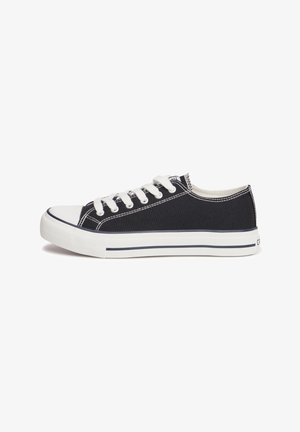 Black canvas sneaker with white rubber sole, white laces, and contrasting stitching. Classic low-top design with a rounded toe.