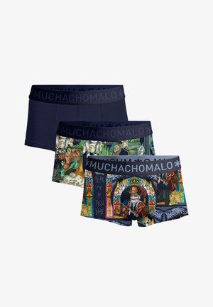 Drie herenboxers met zwarte elastische taillebanden met het merk "MUCHACHOMALO"; één effen marineblauw, één met leeuwen en vintage illustraties, één met middeleeuwse taferelen.