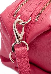 Borsa in pelle rosa con superficie testurizzata, zip dorata e clip argentata per la tracolla. Cuciture visibili e design con chiusura sicura.