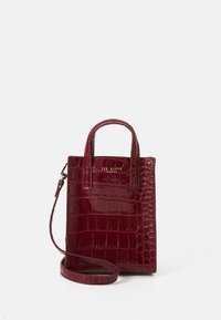 Sac à main en cuir rouge effet croco avec deux poignées courtes et une bandoulière amovible. Présente un design structuré et un détail logo.