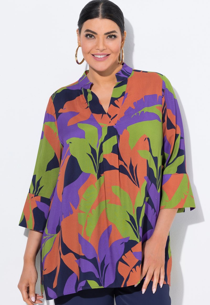Mehrfarbige Bluse mit floralem Muster in Lila, Grün und Orange. Hergestellt aus leichtem Stoff mit V-Ausschnitt und Dreiviertelärmeln.