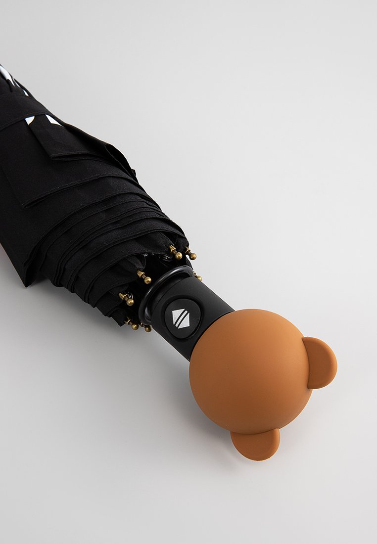 Parapluie noir avec un poign handle en forme d'ours brun arrondi, avec une surface texturée et un bouton circulaire sur une prise noire. Accents dorés présents.