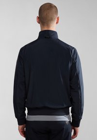 Mørkeblå letvægtsjakke med opretstående krave, elastiske manchetter og lige bund; glat stof med minimalistiske designdetaljer.