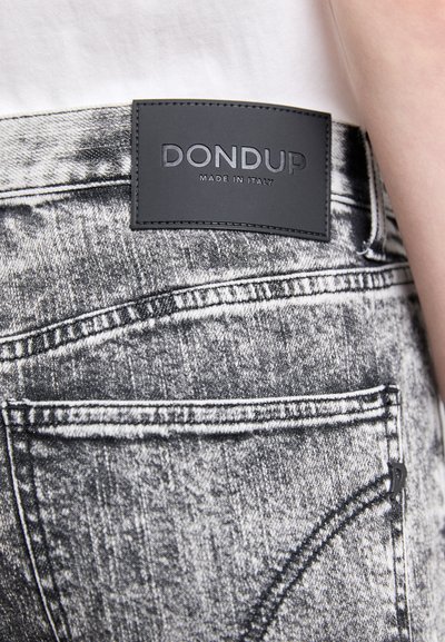 Black and white denim jeans with a distressed texture, featuring a black leather patch labeled "DONDUP MADE IN ITALY" on the waistband.
