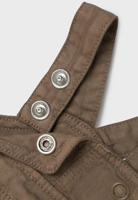 Tirantes de overall de algodón marrón con un patrón de espiga texturizado, broches de metal plateado y costuras reforzadas para mayor durabilidad.