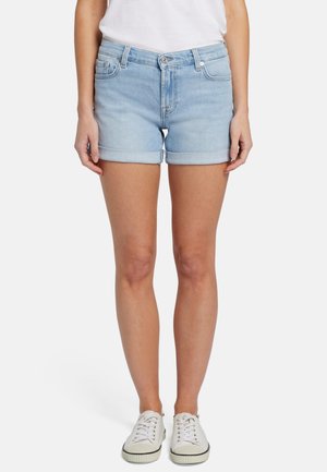 Lichtblauwe denim shorts met een omgeslagen zoom, vijf zakken en een aangesloten ontwerp, gecombineerd met witte sneakers.