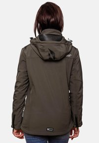 Person wearing dark gray hooded outdoor jacket with brand logos on hood, back, and sleeve, shown from the back.