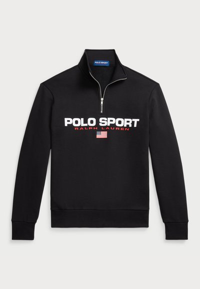 Črna pulover s prednjim zadrgo iz mehkega materiala, ki ima velik bel logotip "POLO SPORT", rdeče detajle in majhen grafični prikaz ameriške zastave.