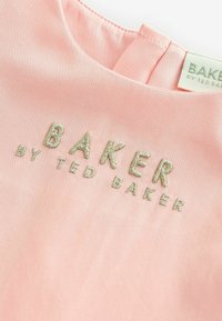 Tissu rose avec broderie "BAKER by TED BAKER" en fil vert clair. Texture douce avec un col rond et une étiquette contrastante.