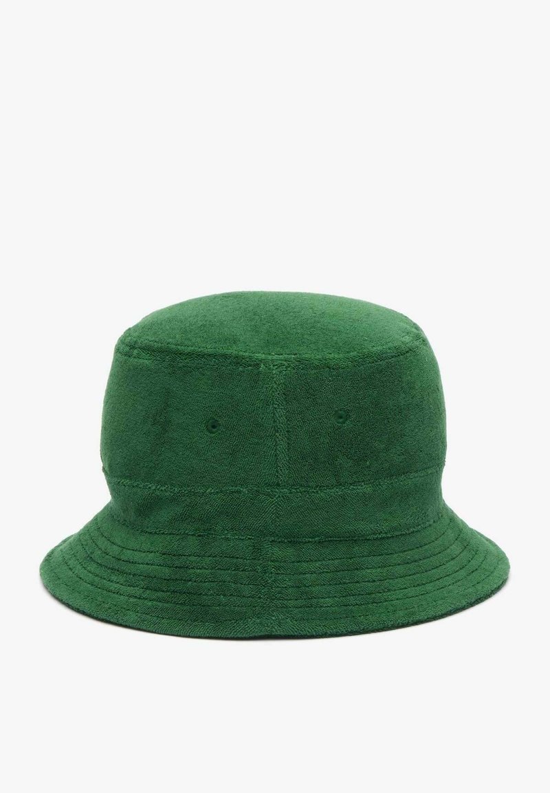 Zielona bawełniana czapka typu bucket z zaokrąglonym rondem, miękką teksturą i poziomymi detalami szewnymi wokół ronda. Brak widocznych elementów metalowych.