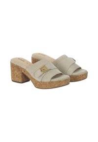 Mule in suede beige chiaro con tacco a blocco in sughero. Presenta una fascia ampia con un dettaglio dorato e un design con punta aperta.