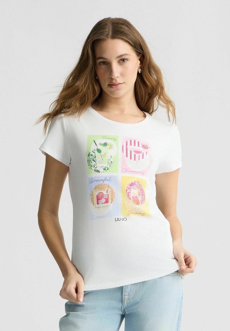 T-shirt en coton blanc avec quatre imprimés graphiques colorés comportant les mots : "Drôle," "Charmant," "Gracieux," "Rêveur." Manches courtes, encolure ronde.