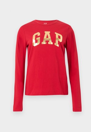 Raudonas ilgomis rankovėmis marškinėlis su apvalia apykakle, ant krūtinės centre didelis blizgus auksinis "GAP" logotipas.