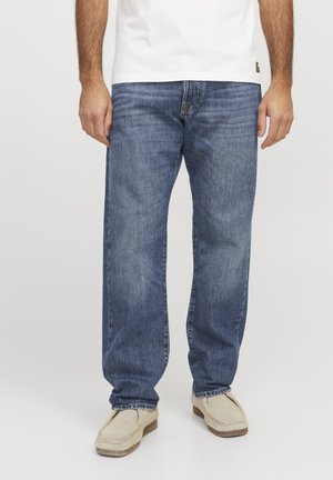 Helle blaue Denim-Jeans mit geradem Bein, ausgestattet mit einer Vordertasche, Gürtelschlaufen und sichtbaren Nähdetails. Getragen mit beigen Schuhen.