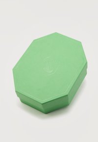 Οκταγωνικό πράσινο κουτί με ανάγλυφο λογότυπο κύκνου στο καπάκι, τοποθετημένο σε λευκό φόντο.