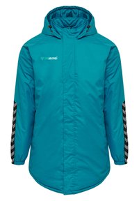 Türaufpolsterte Jacke in Tealfarbe mit Kapuze, ausgestattet mit einem schwarzen Chevron-Design entlang der Ärmel und einem Logo auf der Vorderseite. Verstellbarer Kordelzug an der Kapuze.