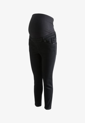 Schwarze Umstandsjeans mit elastischem Überbauchpanel, das einen Babybauch stützt, auf weißem Hintergrund dargestellt.
