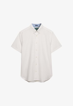 Chemise blanche à manches courtes avec boutons et col boutonné, coupe régulière et boutons beige clair, présentée sur un fond blanc.