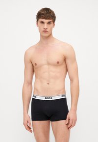 Schwarze Baumwoll-Boxershorts mit einem weißen Bund, der das "BOSS"-Logo trägt. Entworfen für eine enganliegende Passform mit einer glatten Textur.