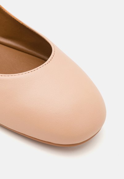 Nude leren ballerina met een ronde neus, met een gladde textuur en minimale stiksels voor een eenvoudig ontwerp.