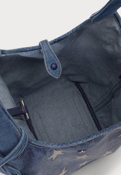 Torba typu tote z denimu w jasnoniebieskim kolorze z miękką podszewką wewnętrzną. Zawiera zapięcie na zatrzask, kieszenie wewnętrzne oraz kontrastujące przeszycia.