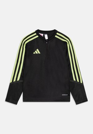 Schwarzes langärmliges Sportoberteil mit neongrünen dreifachen Streifen an den Ärmeln, Frontreißverschluss, Adidas-Logo auf der Brust und "AEROREADY"-Text nahe dem Saum.