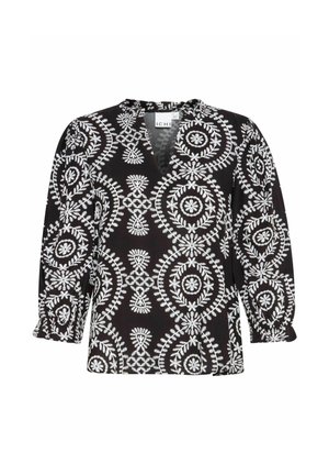 Blouse noire avec broderie florale blanche, présentant un décolleté en V, des manches bouffantes trois-quarts et une coupe ample. Tissu texturé avec un design à motifs.