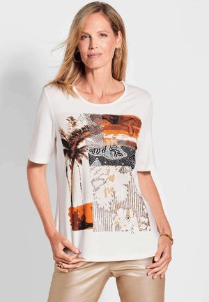 Kurzärmliges weißes T-Shirt mit einem bunten Grafikdruck in Erdtönen, einschließlich Orange und Schwarz, sowie strukturierten Mustern.